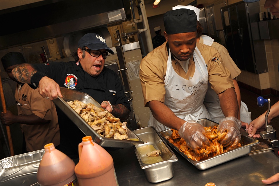 Celebrity chef shows how to prepare chicken wings for sailors at naval station